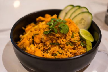 Tom Yum pilavı ve siyah kase içinde deniz ürünleri. Tayland yemeği.