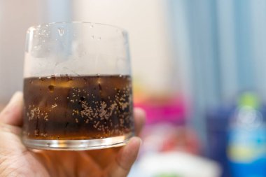 Bardakta meşrubat tutan bir adam.