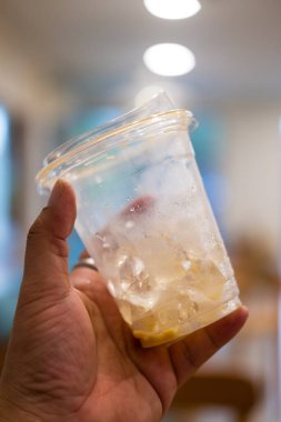 Buzlu kahve fincanını yakın çekimde, arka planda bulanıklık olan küçük bir buzla birlikte.