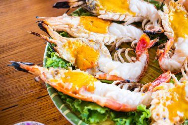 Taze ızgara nehir karidesi ya da karides. Yarısını kes ve yak. Karides kafası kremalı turuncu renkte ve son derece lezzetli olacak..