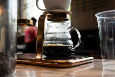 Alternatif kahve demleme metodu, damlatıcı ve kağıt filtresinin üzerine dökülüyor. Barista damlatan kahve yapıyor.