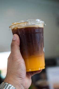 Bir bardak buzlu Americano sade kahve ve bir tabaka portakal suyu.