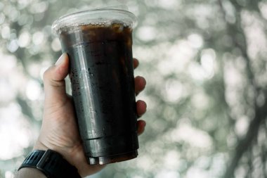 Paketlenmiş plastik fincan buzlu sade kahvenin yakın çekimi.