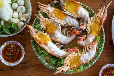 Luxury large river prawns cooking by firm meat are grilled on a charcoal stove. The head of the shrimp is greasy served on plates clipart