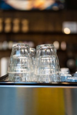 Kafedeki bir kahve makinesinin üzerinde baş aşağı duran temiz bardaklar..