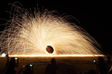 Ateş dansı gösterisi, gece vakti Tayland 'da kumsalda uzun pozlar.