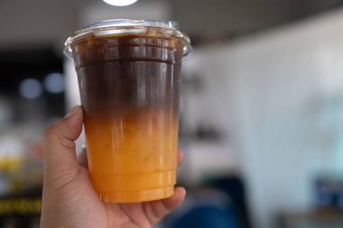 Buzlu Americano sade kahve ve bir tabaka portakal suyu.