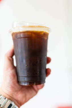 Sade kahve, buzlu kahve. Paket paket. Elinde buz olan plastik bardak.