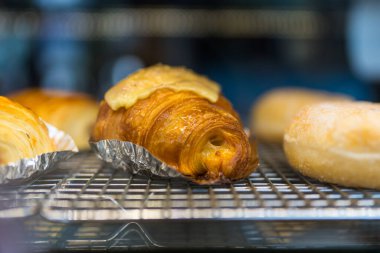 Fırındaki rafta taze kruvasan var.