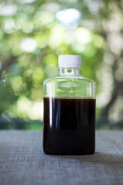 Buzlu soğuk kahve. Boş etiket şişesinde. Arka planda beyaz kapaklı..