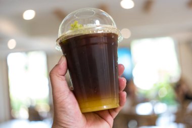 Buzlu americano sade kahve. Portakal suyu karışımı. Arka planda bulanık.