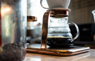 Alternatif kahve demleme metodu, damlatıcı ve kağıt filtresinin üzerine dökülüyor. Barista damlatan kahve yapıyor.