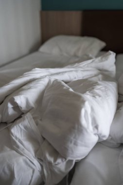Beyaz yatak arka planı, otelde uyuduktan sonra, kirli yatak.