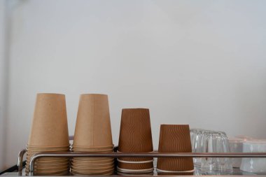 Minimum kafe ya da restoranda kahve makinesinin üzerinde sıra sıra dizilmiş kağıt kahve fincanı