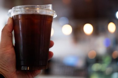 Elinde plastik bir fincan buzlu sade kahveyle fotokopi alanı var..