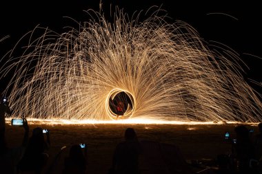 Ateş dansı gösterisi, gece vakti Tayland 'da kumsalda uzun pozlar.