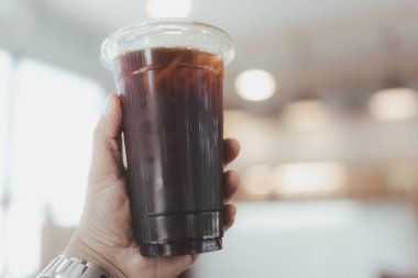 Kahve dükkanında elinde buzlu kahve tutan adamı kapat.