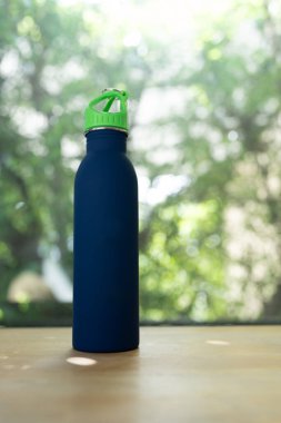 Mavi bir su şişesi arka planda dimdik ayakta duruyor.