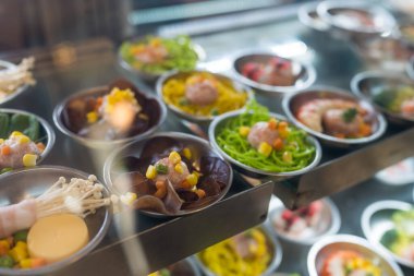 Lokantada buharda pişmeye hazır bir sürü Çin mantısı sergileniyor.