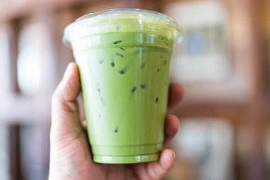 Buzlu Matcha latte 'nin plastik bardaktaki yakın görüntüsü.