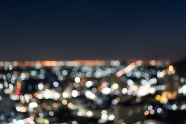 Şehirde geceleri gökyüzüne yükselen renkli odaklanmış ışıklar.