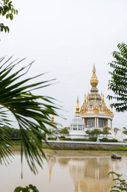 Wat Thung Setthi. Tayland 'ın beyaz dış görünüşlü, altın ve mavi aksanlı tapınağı ve Tayland' ın Khon Kaen eyaletinde bir bataklığın ortasında.