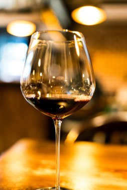 Bir şarap kadehi yemek masasında kırmızı şarapla doludur..
