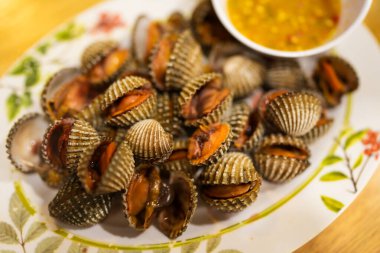 Haşlanmış midyeler baharatlı Tayland deniz ürünleri sosuyla yenir.