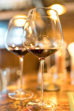 Yemek masasında kırmızı şarap bardakları. İki kırmızı şarap kadehi.