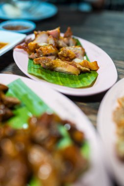 Tayland usulü ızgara domuz boynu ve ahşap masada bir sürü Kuzeydoğu yemeği.