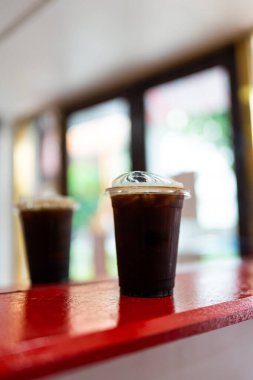 Buzlu Americano kahvesi, bardakta, kırmızı ahşap bardakta.