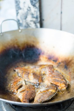 Sıcak yağ tavasında taze tilapia balığı kızartıyorum.