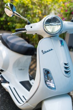 Bangkok, Tayland - 27 Mart 2025: Parlak güneş ışığı altında beyaz bir vespa LX125 ön görüş, yuvarlak bir far