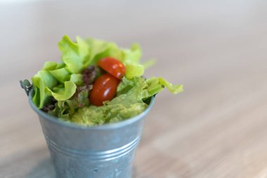 Tahta masada yemek için mini kovada organik yeşil meşe marulu.