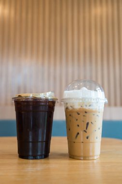 Buzlu kahveyi, sütlü kahveyi ve sade kahveyi ahşap masaya koy.