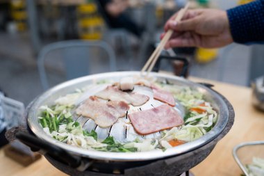 Tanınmayan adam açık hava restoranında Moo Ka Ta ya da Thai BBQ yemek ve yemek yemekten hoşlanıyor.