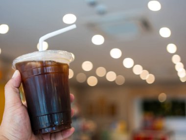 Elinde bir bardak buzlu kahve ve fotokopi alanı olan bir adama yaklaş.