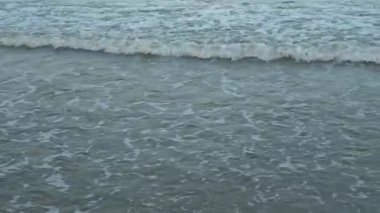 Deniz dalgasını kapatın. Köpüklü suyu sakinleştirmek için yaz tatili konseptini kullan. Plajda tatil. Yaz günü sahilin manzarası..