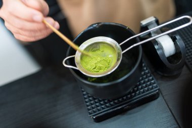 Yeşil çay hazırlamak için elek kullanan biri. Kibrit yeşil çay yapıyorum