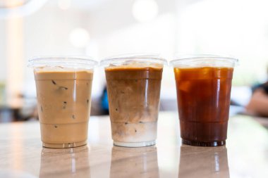 Yaz mevsiminde bir kahvecinin masasında üç bardak buzlu kahve, menü fotoğrafçılığı.