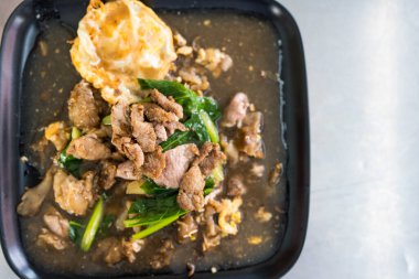 Soslu domuz etli erişte ve yumurta ile birlikte servis edilen lahana.