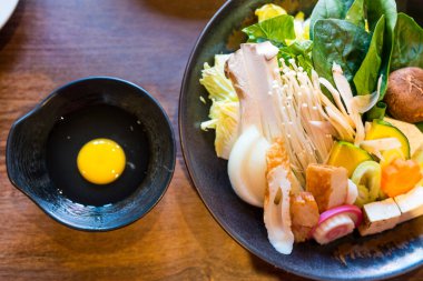 Shabu için taze sebze ve çiğ yumurta hazır. Üst görünüm