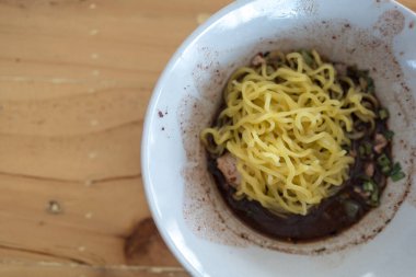 Tahta masadaki küçük bir kasede lezzetli Tayland gemisi sarı şehriye çorbası.