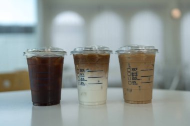 Masada üç bardak buzlu kahve içeceği. Buzlu americano, buzlu latte ve buzlu moka..