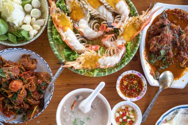 Tayland restoranının ahşap masasında çeşitli Tayland deniz ürünleri.