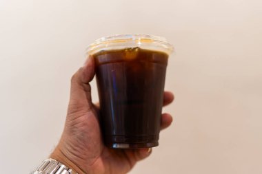 El ele tutuşmuş buzlu kahve ya da kahve bardağında Amerikan kahvesi.