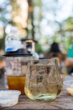 Viskili soğuk bir içecek, buz küpleri ve ahşap masada soda.
