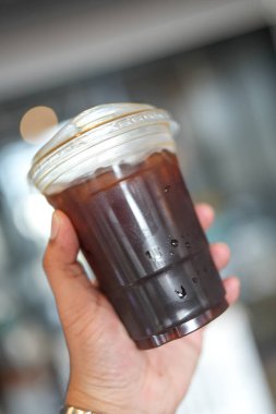 Biri elinde bir fincan buzlu Americano tutsun. Kapat.