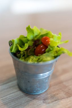 Tahta masada yemek için mini kovada organik yeşil meşe marulu.
