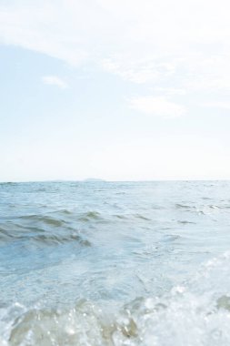 Deniz dalgaları mavi gökyüzüne karşı, Chonburi, Tayland 'da Bangsan sahilinde bulutlar.